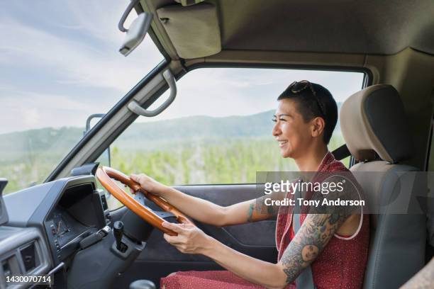 young woman driving camper van - anti us stock-fotos und bilder