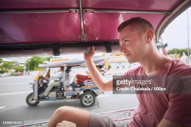 man enjoying a tuk tuk ride in bangkok - rickshaw stock pictures, royalty-free photos & images