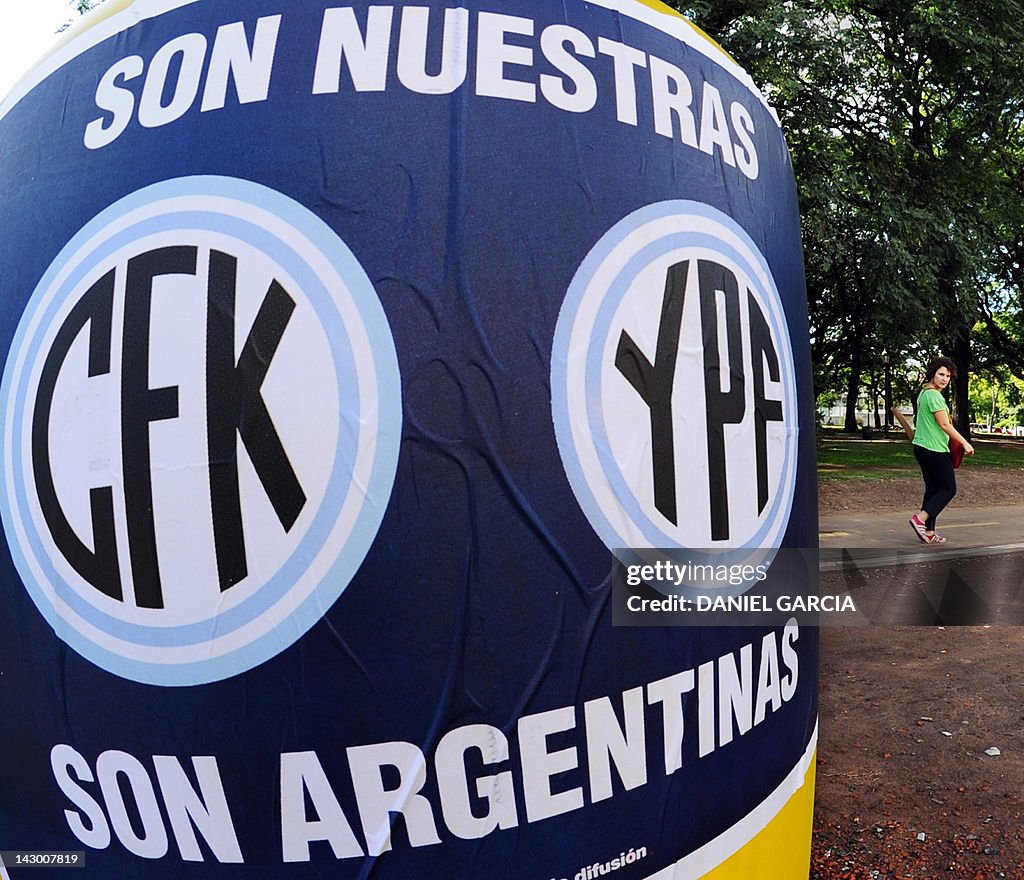 A woman walks past a poster making refer