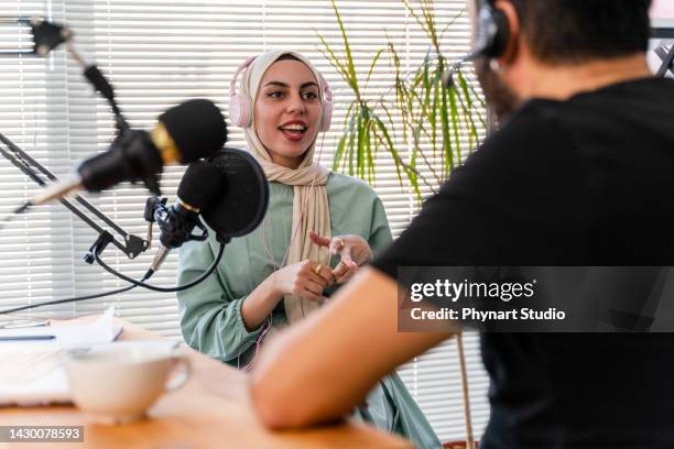 intervista e discussione tra un blogger e una donna musulmana ospite in un podcast show dal vivo - topnews foto e immagini stock