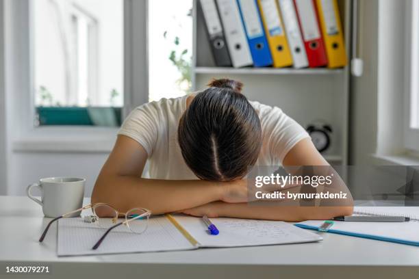 tired girl sleeping at her desk - woman sleeping table stock pictures, royalty-free photos & images