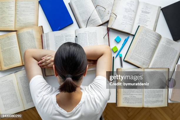 tired girl doing homework at her desk - book table stock pictures, royalty-free photos & images