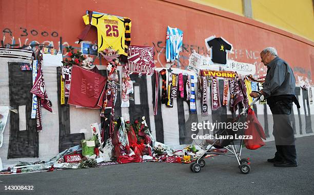 Man views floral and graffiti tributes outside Armando Picchi Stadium, where the coffin of footballer Piermario Morosini was displayed for fans and...