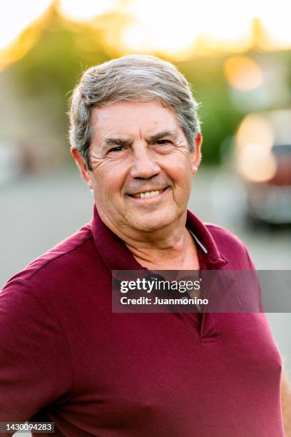 smiling mature senior caucasian man looking at the camera - alleen seniore mannen stockfoto's en -beelden