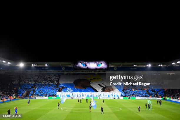 Leicester City fans show their support with a banner of former captain Wes Morgan kissing the Premier League trophy prior to the Premier League match...