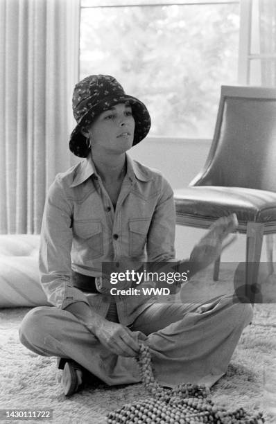 Actress Ali MacGraw sits on rug and answers questions during an interview in her friend's apartment.