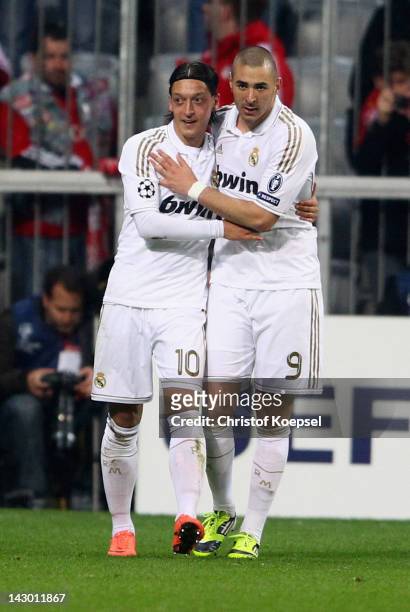 Mesut Oezil celebrates the first goal with Karim Benzema of Real Madrid during the UEFA Champions League Semi Final first leg match between FC Bayern...
