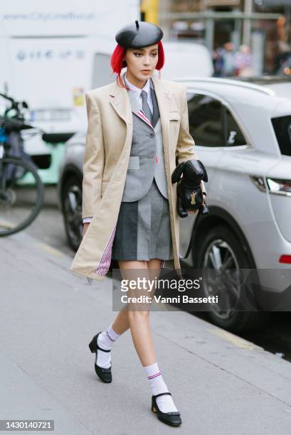 Kiwi Lee poses wearing Thom Browne trench coat, Thom Browne jacket and skirt and a Thom Browne Pebbled hector bag after the Thom Browne show at the...