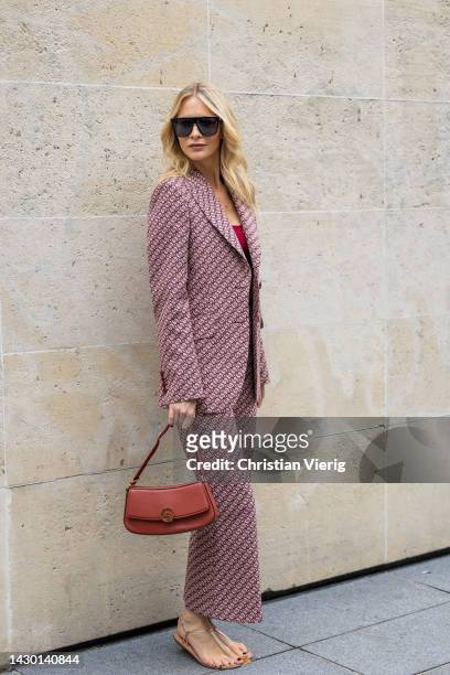 Poppy Delevingne wears suit, cropped red top, bag, sandals outside Stella McCartney during Paris Fashion Week - Womenswear Spring/Summer 2023 : Day...