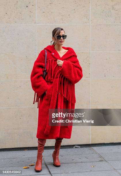 Gabrielle Caunesil Pozzoli wears red hooded coat, boots outside Stella McCartney during Paris Fashion Week - Womenswear Spring/Summer 2023 : Day...