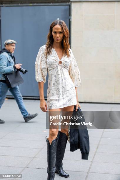 Joan Smalls wears white dress, black cowboy boots outside Stella McCartney during Paris Fashion Week - Womenswear Spring/Summer 2023 : Day Eight on...