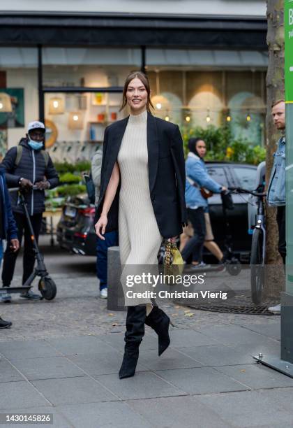 Karlie Kloss wears knitted latte dress, black blazer, yellow bag, boots outside Stella McCartney during Paris Fashion Week - Womenswear Spring/Summer...