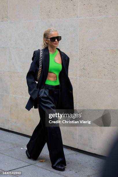 Caroline Caro Daur wears green cut out asymmetric top, black pants, blazer outside Stella McCartney during Paris Fashion Week - Womenswear...