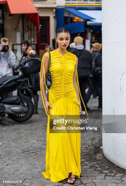 Guest wears yellow dre outside Stella McCartney during Paris Fashion Week - Womenswear Spring/Summer 2023 : Day Eight on October 03, 2022 in Paris,...