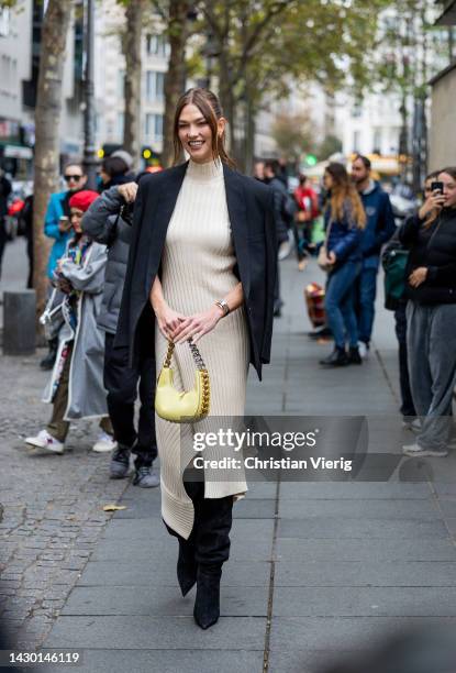 Karlie Kloss wears knitted latte dress, black blazer, yellow bag, boots outside Stella McCartney during Paris Fashion Week - Womenswear Spring/Summer...