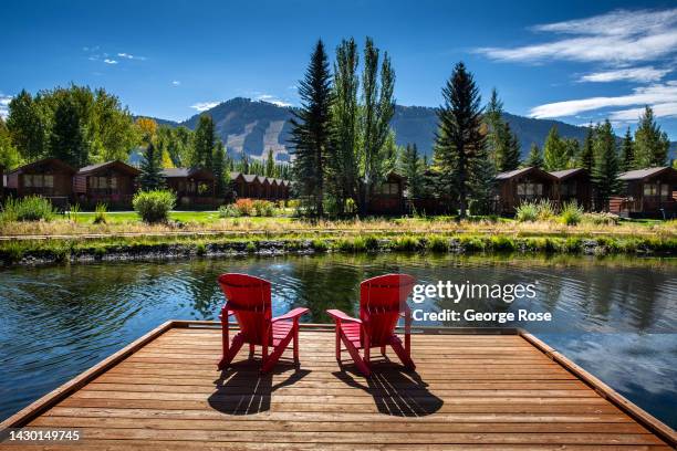 Adirondack chairs are situated along Flat Creek at the Rustic Inn near downtown Jackson and across the street from the National Elk Preserve on...