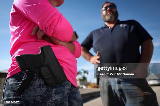 Pine Island resident Jamie Surgent wears a pistol on her hip while working on cleanup and recovery efforts in the wake of Hurricane Ian on October...