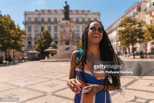 mujer afro sonriente en la plaza de lisboa - luís vaz de camões fotografías e imágenes de stock