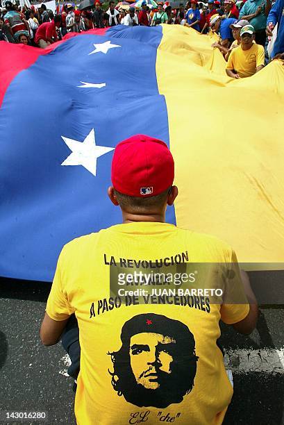Supporters of Venezuelan President Hugo Chavez carry a giant flag during a march in Caracas, 29 July 2002. Thousands of Chavez supporters...