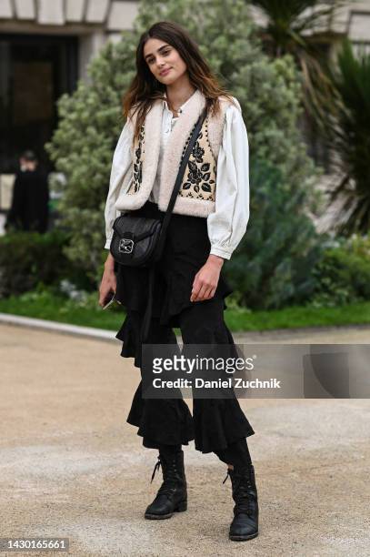 Taylor Hill is seen wearing a white shirt, cream floral vest, black ruffled pants and black bag outside the Zimmermann show during Paris Fashion Week...