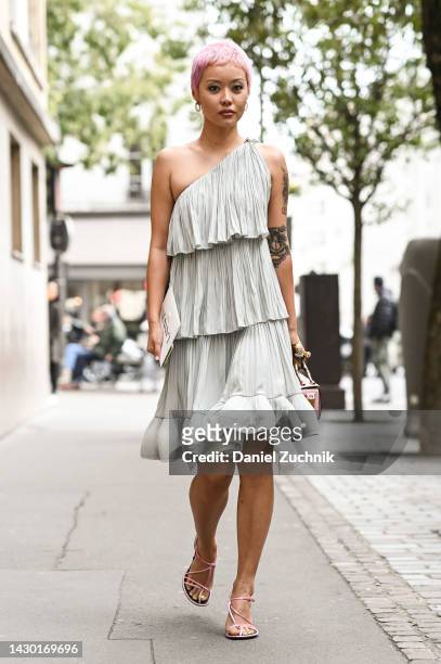 Guest is seen wearing a ruffled Lanvin dress and Lanvin pink and gold bag and pink laced flats outside the Lanvin show during Paris Fashion Week S/S...