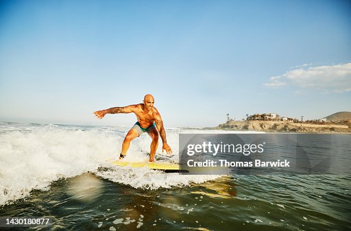 Man Riding Wave Wide Shot Of Smiling Man Riding Wave While Taking Surf Lesson High-Res ...