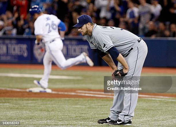 Jeff Niemann of the Tampa Bay Rays reacts as Adam Lind of the Toronto Blue Jays rounds first after a two run home run during MLB action at the Rogers...