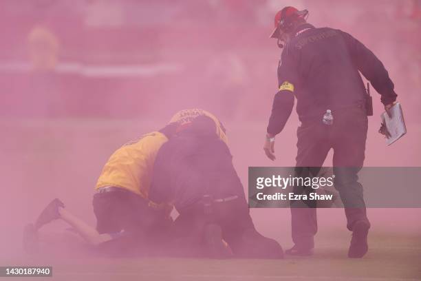 Fan is detained by security after running onto the field as the Los Angeles Rams play against the San Francisco 49ers at Levi's Stadium on October...