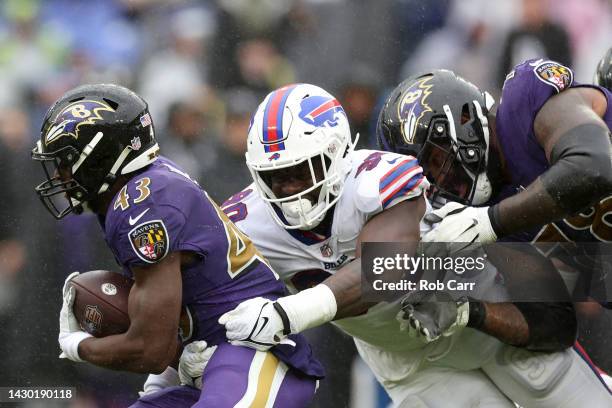 Defensive end Shaq Lawson of the Buffalo Bills tackles running back Justice Hill of the Baltimore Ravens at M&T Bank Stadium on October 02, 2022 in...