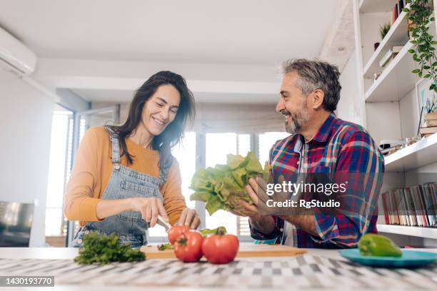 家庭で新鮮な野菜からサラダを作る成熟した男女 - middle aged couple cooking ストックフォトと画像