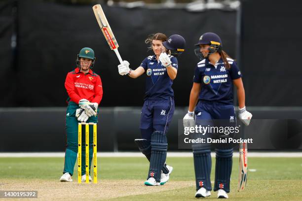 Annabel Sutherland of Victoria raises her bat after making a century during the WNCL match between Victoria and Tasmania at CitiPower Centre, on...