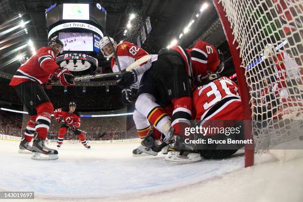 Andy Greene of the New Jersey Devils skates into his teammate goalie Martin Brodeur in the first period against Tomas Kopecky of the Florida Panthers...