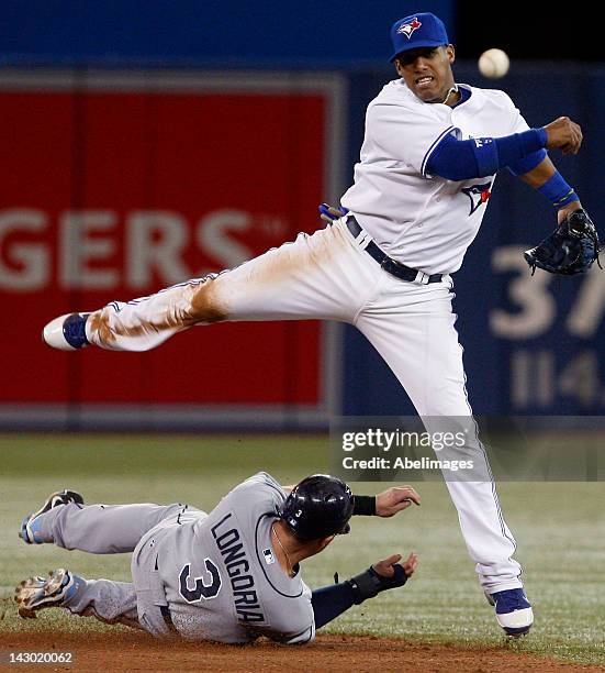 Yunel Escobar of the Toronto Blue Jays makes the double play on Evan Longoria of the Tampa Bay Rays during MLB action at the Rogers Centre April 17,...