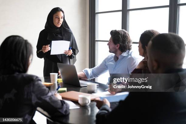 young saudi businesswoman presenting project ideas to team - middle eastern people stock pictures, royalty-free photos & images