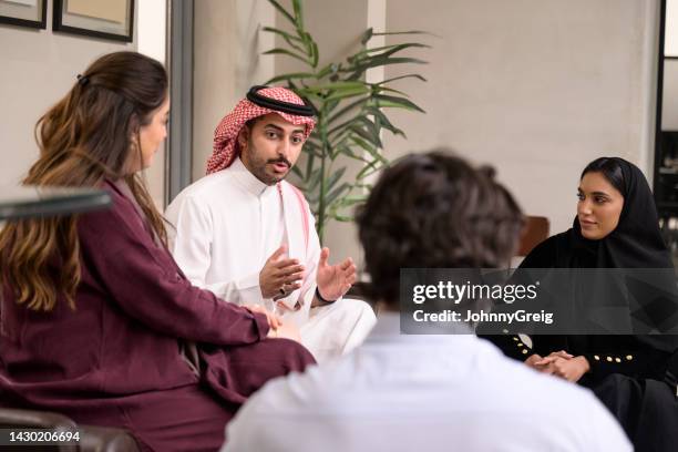 saudi business colleagues in 20s and 30s talking informally - middle eastern culture stock pictures, royalty-free photos & images