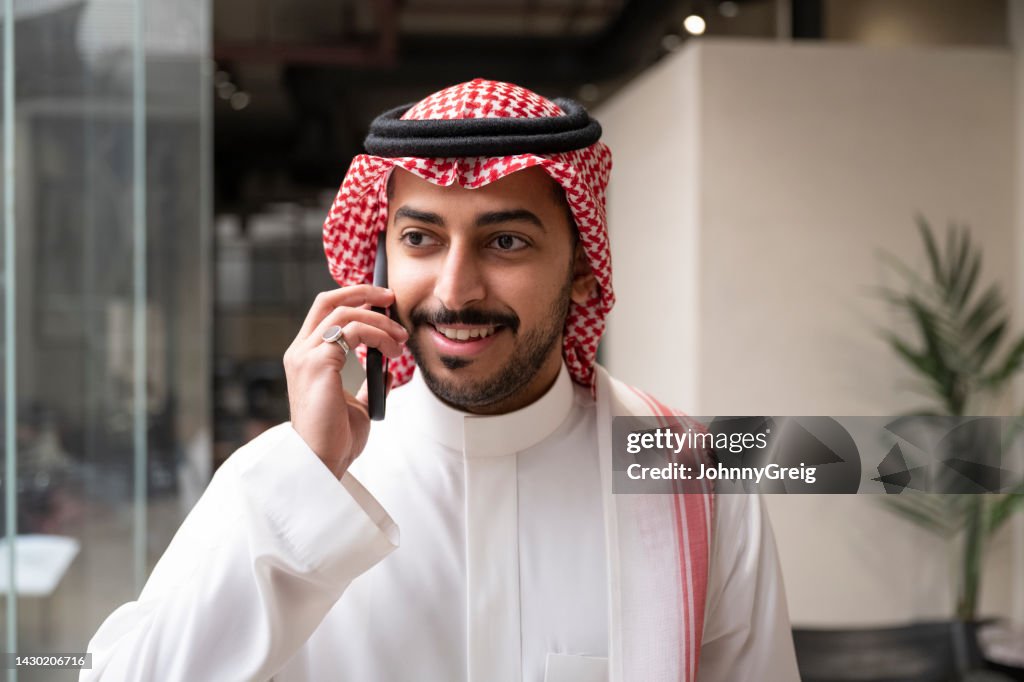 Candid close-up of Saudi businessman using smart phone
