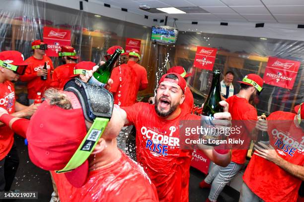 Kyle Schwarber of the Philadelphia Phillies celebrates with teammates in the locker room after clinching the Wild Card, their first playoff berth...