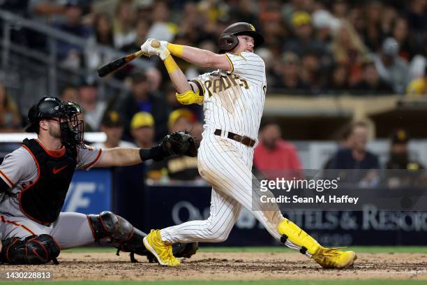 Jake Cronenworth of the San Diego Padres connects for a two RBI double as Joey Bart the San Francisco Giants looks on during the eighth inning of a...