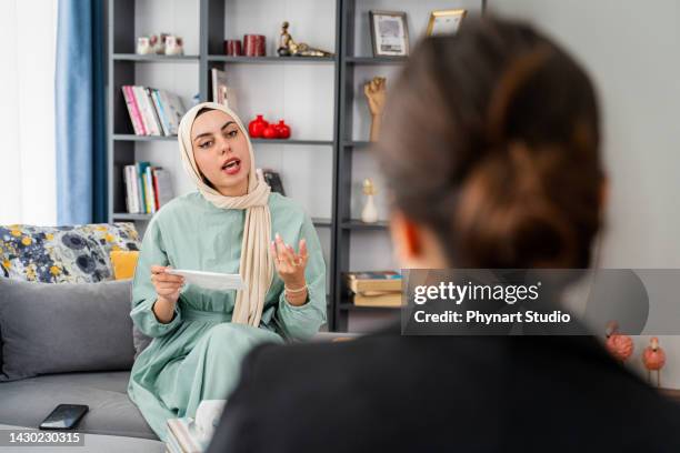 muslim female patient having psychotherapy session at psychologist's office - middle eastern ethnicity stock pictures, royalty-free photos & images
