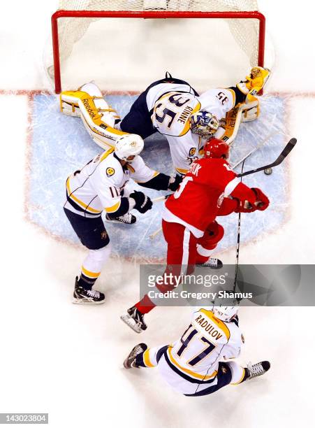 Pekka Rinne of the Nashville Predators makes a save on a shot by Pavel Datsyuk of the Detroit Red Wings with help from teammates Alexander Radulov...