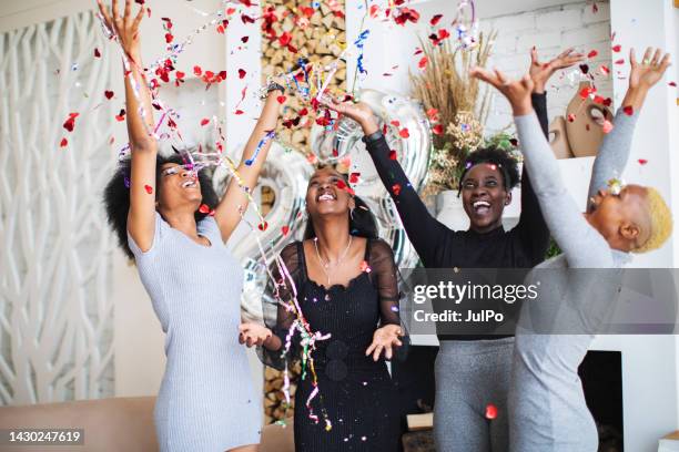 young black women celebrating birthday with party popper at home - party popper stockfoto's en -beelden