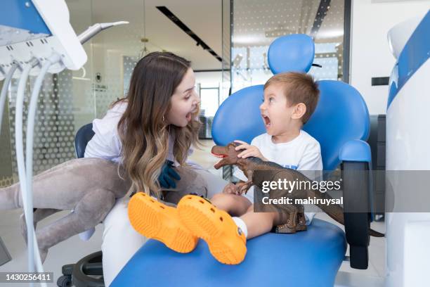 paciente pediátrico joven en silla de dentista - odontopediatría fotografías e imágenes de stock