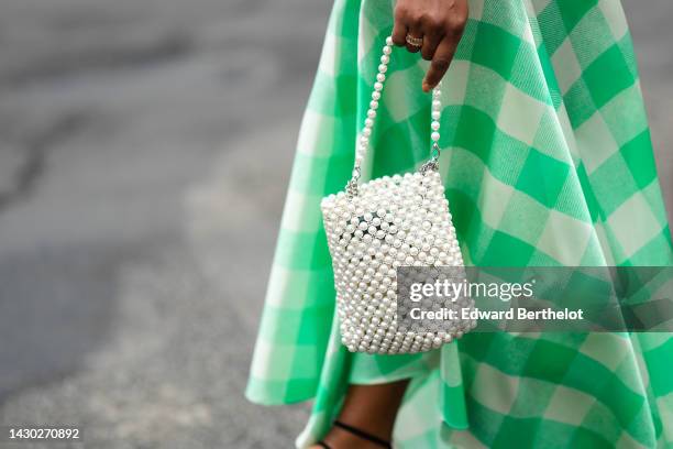 Guest wears a high waist green and white latte checkered print pattern long skirt, a white pearls handbag, outside Botter, during Paris Fashion Week...