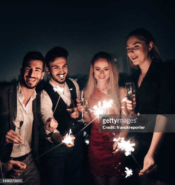 celebrating the new year's eve with sparks - champagne rooftop stock pictures, royalty-free photos & images
