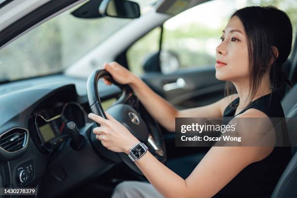 side view of young asian woman driving a car - land vehicle 個照片及圖片檔