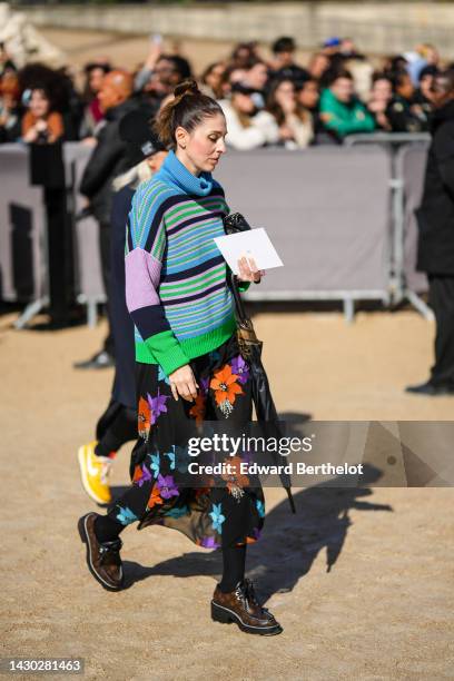 Guest wears a blue / green / black / pale purple striped print pattern oversized pullover, a black with orange / purple / blue flower print pattern...