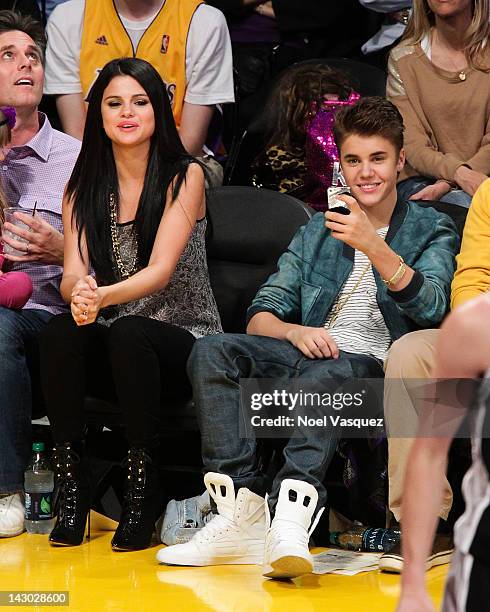 Selena Gomez and Justin Bieber attend a basketball game between the San Antonio Spurs and the Los Angeles Lakers at Staples Center on April 17, 2012...