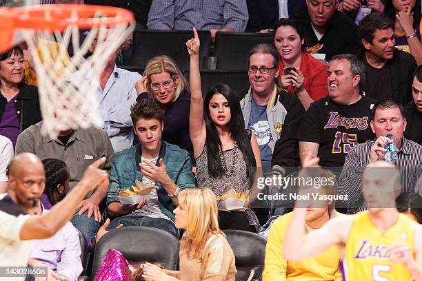 Selena Gomez and Justin Bieber attend a basketball game between the San Antonio Spurs and the Los Angeles Lakers at Staples Center on April 17, 2012...