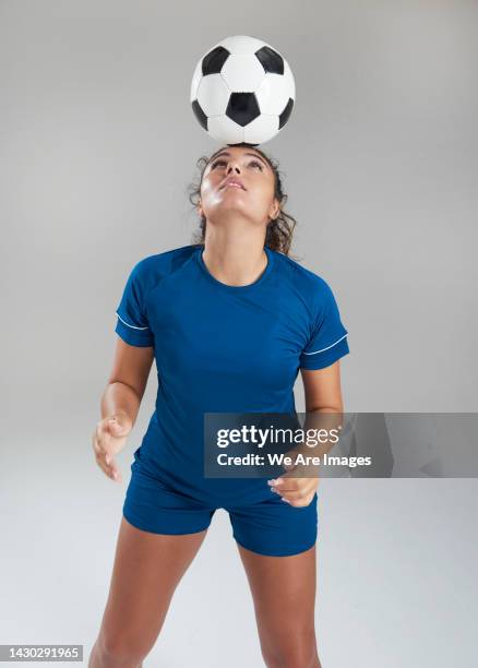 female football player balancing football on head - kopfball stock-fotos und bilder