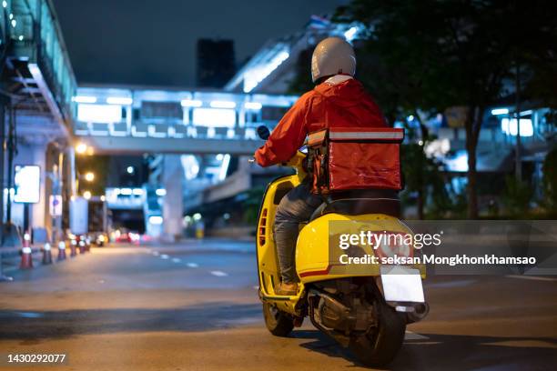 delivery man driving a scooter - motor scooter foto e immagini stock